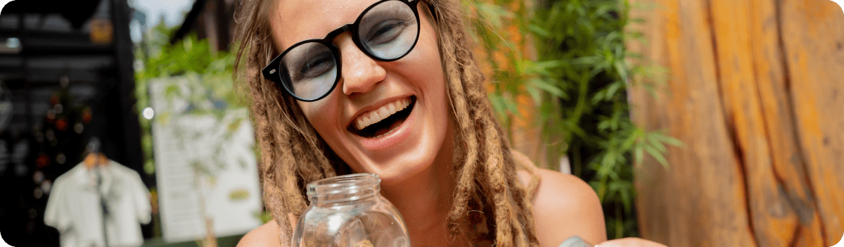 בחורה עם משקפיים על רקע צמח הקנביס